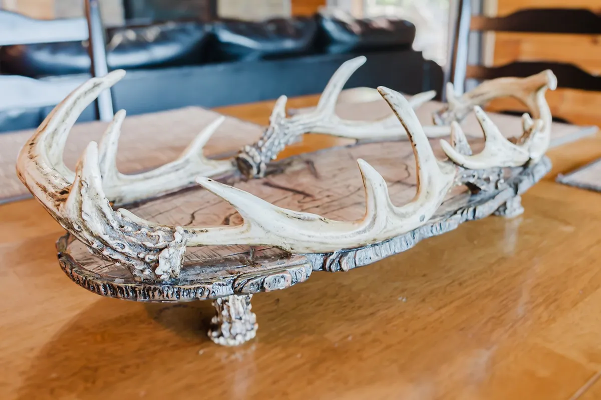 This cozy scene centers on a rustic wooden dining table adorned with an antler centerpiece, suggesting festive meals and special gatherings. The ambiance is warm and intimate, perfect for celebrations, shared meals, and group bonding.