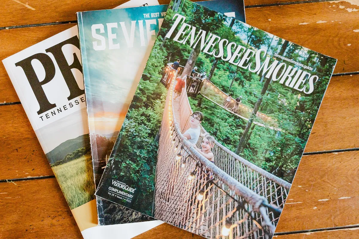 This image features a wooden table surface scattered with travel brochures, inviting guests to browse local attractions and plan exciting outings during their stay. The warm wood tones and natural light evoke a sense of curiosity and adventure, hinting at the exclusive local perks awaiting guests.