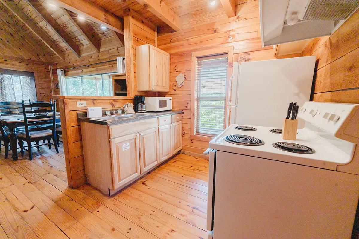 A fully equipped kitchen complete with a spacious counter, stove, and adjacent dining table. The open layout invites group cooking, shared meals, and easy flow between kitchen and gathering areas.